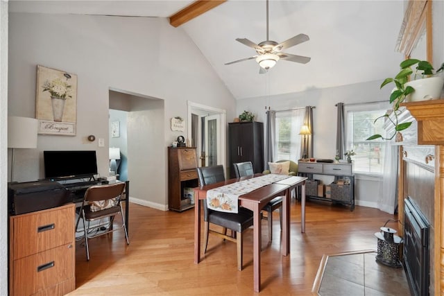 dining room with ceiling fan, light hardwood / wood-style flooring, high vaulted ceiling, and beamed ceiling