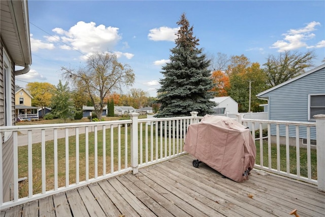 wooden terrace featuring grilling area and a lawn