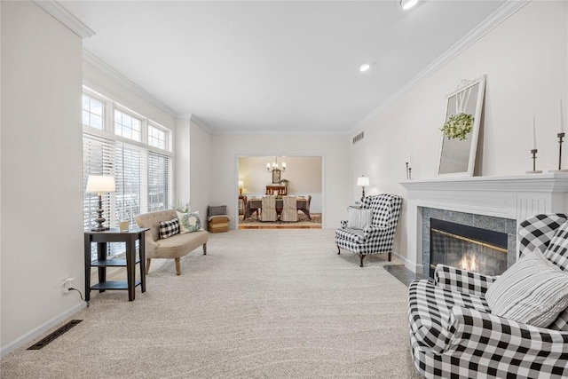 living area featuring a fireplace, light carpet, crown molding, and a notable chandelier