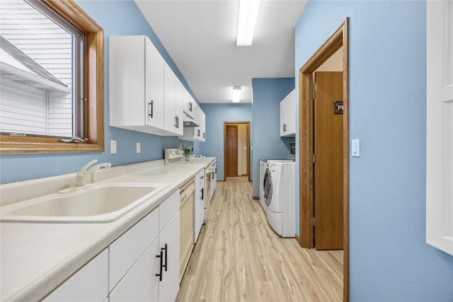 kitchen featuring light hardwood / wood-style flooring, sink, white cabinetry, separate washer and dryer, and range