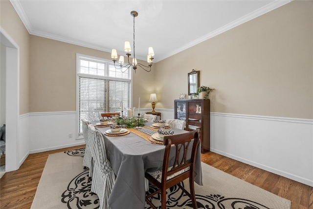 dining area with crown molding, a chandelier, and wood-type flooring