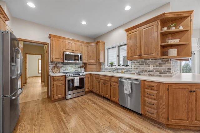 kitchen featuring light hardwood / wood-style floors, stainless steel appliances, tasteful backsplash, and sink