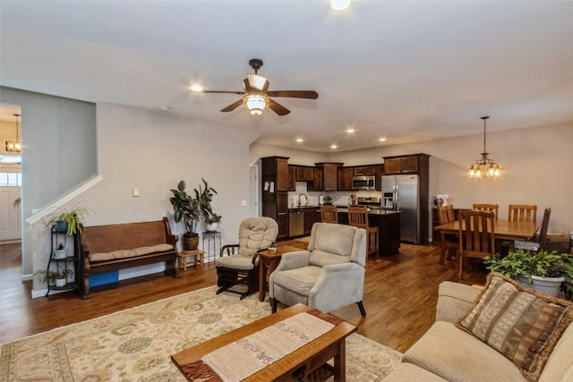 living room featuring sink, ceiling fan with notable chandelier, and dark hardwood / wood-style flooring