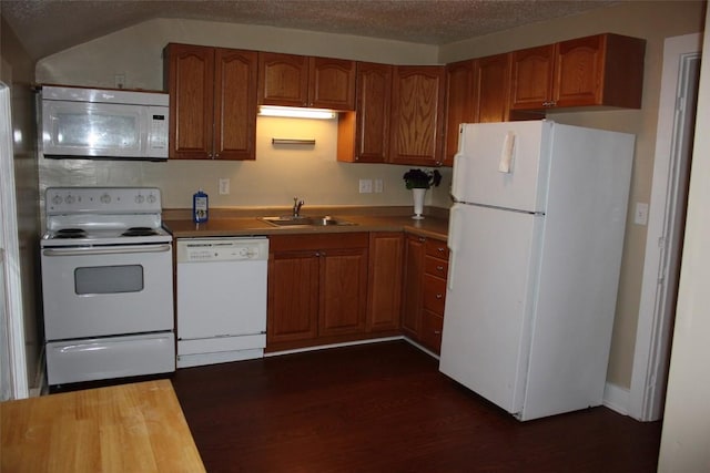 kitchen with dark hardwood / wood-style flooring, sink, white appliances, and a textured ceiling