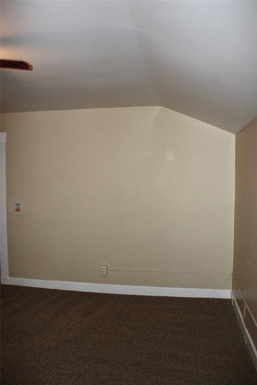 bonus room featuring lofted ceiling and dark carpet