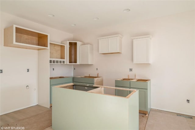 kitchen with sink, white cabinets, a center island, and green cabinetry