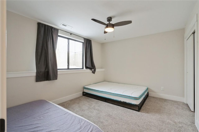 bedroom with ceiling fan, a closet, and light colored carpet