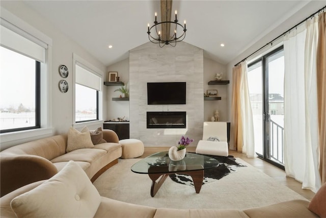 living room featuring a fireplace, lofted ceiling, and a chandelier