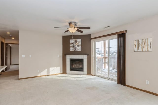 unfurnished living room featuring ceiling fan, light colored carpet, and a fireplace