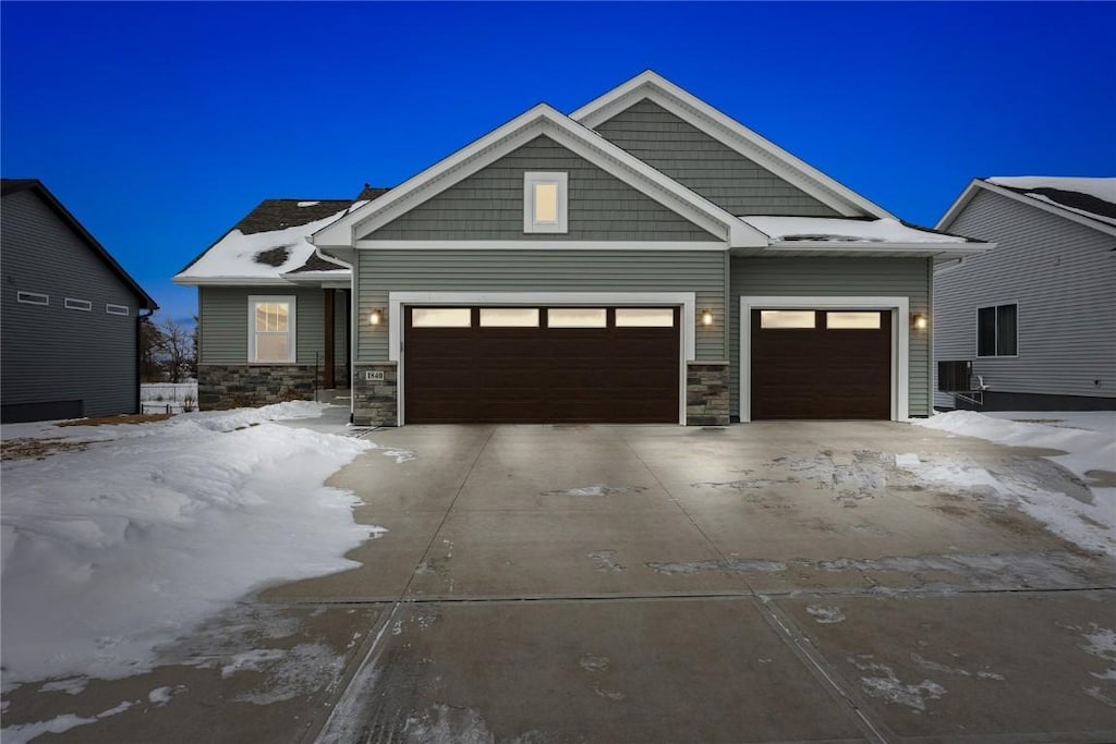 view of front of property featuring a garage and cooling unit