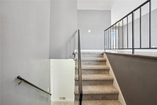 staircase featuring carpet