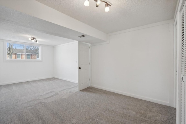 carpeted empty room with a textured ceiling