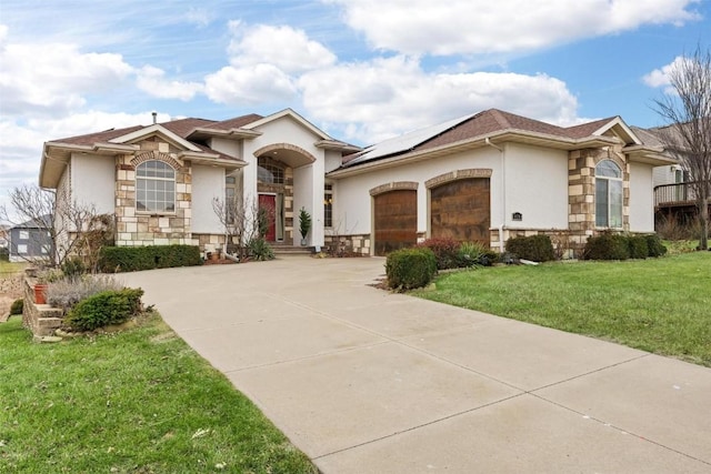 view of front of property with a front lawn, a garage, and solar panels