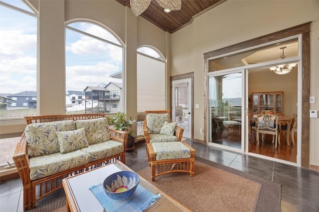 sunroom with vaulted ceiling, an inviting chandelier, and wooden ceiling