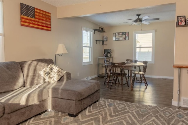 living room featuring a textured ceiling, dark hardwood / wood-style floors, and a healthy amount of sunlight