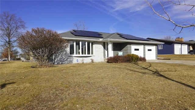 ranch-style house with a front lawn, solar panels, and a garage