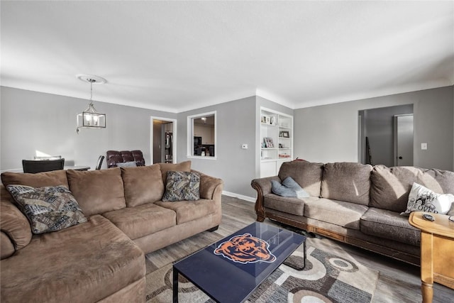 living room featuring a chandelier, dark hardwood / wood-style floors, and built in features