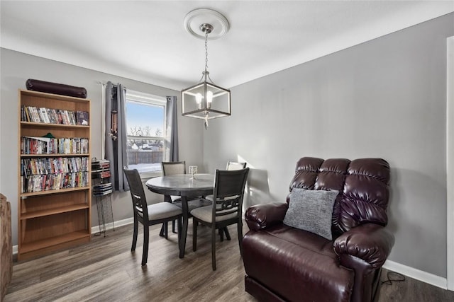 dining space featuring hardwood / wood-style flooring and an inviting chandelier