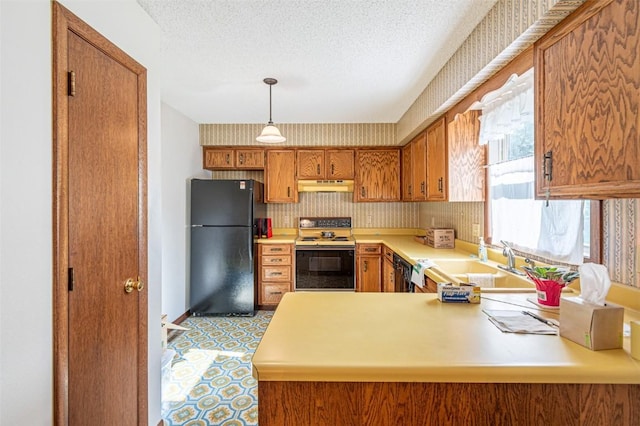 kitchen featuring sink, black fridge, a textured ceiling, range with electric stovetop, and kitchen peninsula