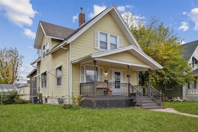 view of front of house featuring central AC unit, a front lawn, and a porch