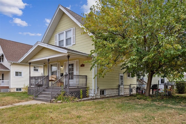 bungalow with a porch, a front yard, and fence