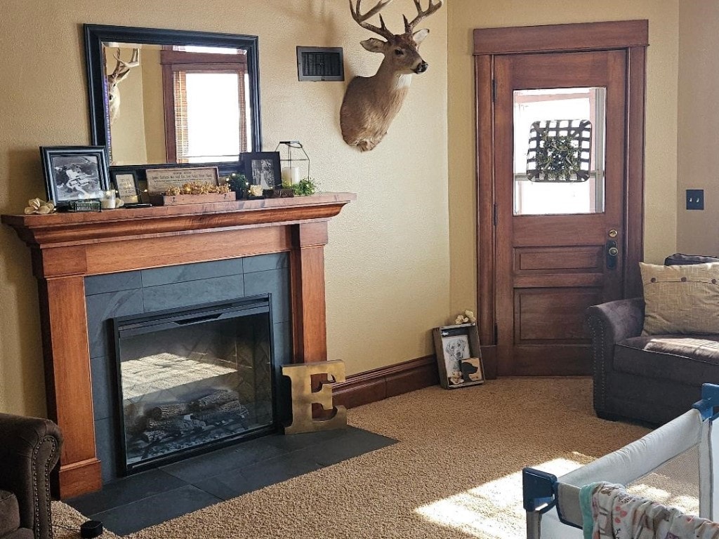 living room featuring dark carpet, plenty of natural light, and a fireplace