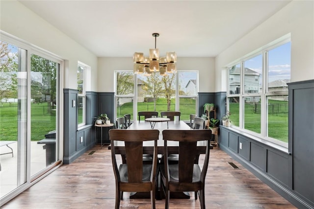 sunroom with a chandelier, a healthy amount of sunlight, and visible vents