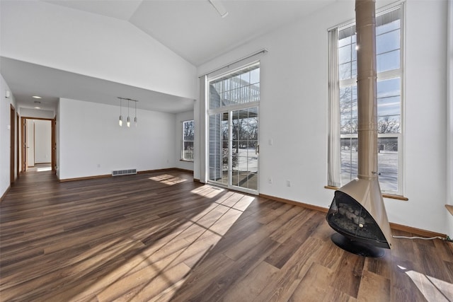 unfurnished living room with high vaulted ceiling, wood finished floors, visible vents, and baseboards