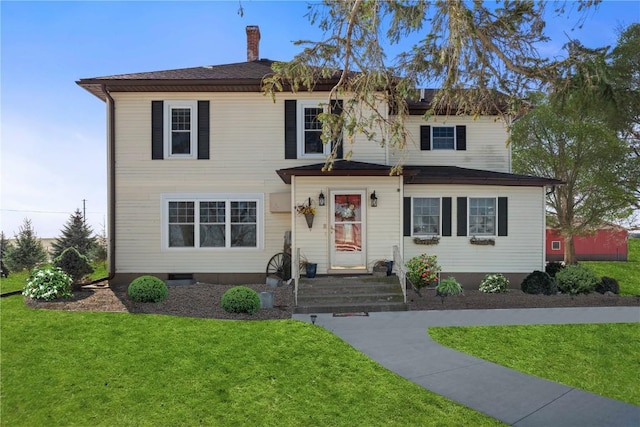 traditional home featuring a chimney and a front yard