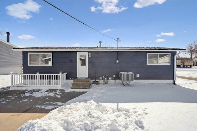 snow covered house with central AC unit