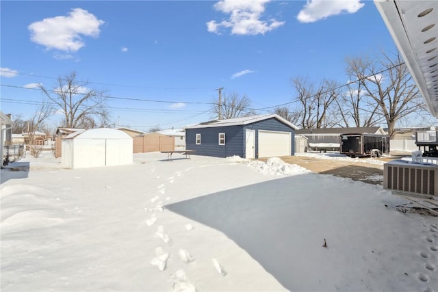 exterior space featuring a shed, an outdoor structure, fence, and a detached garage