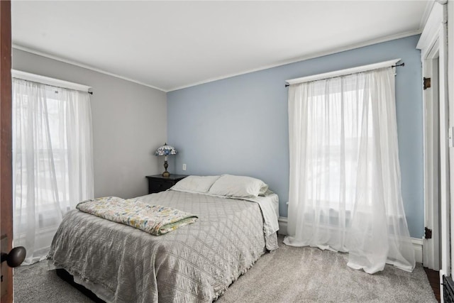 carpeted bedroom with ornamental molding and multiple windows