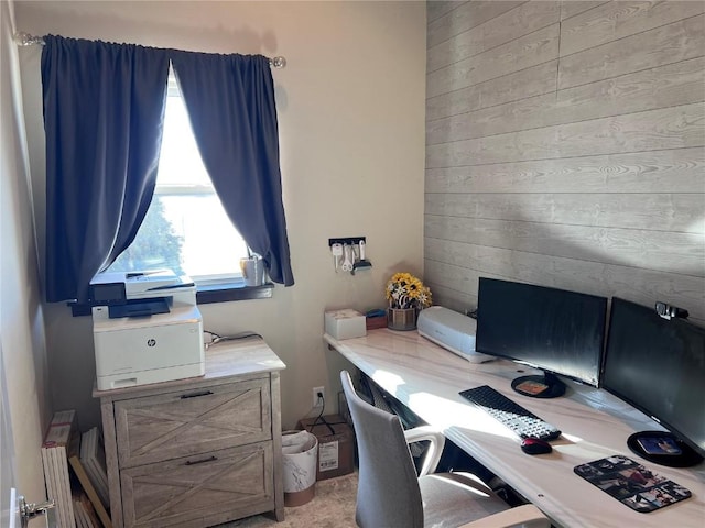 home office featuring light carpet, wood walls, and radiator heating unit