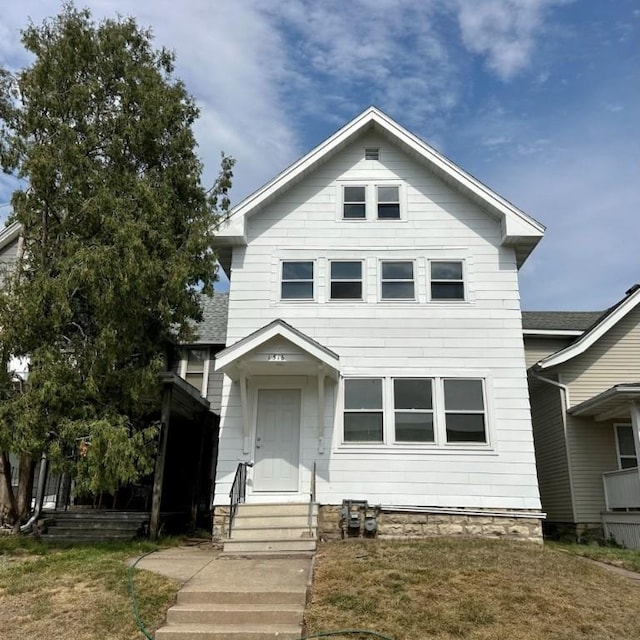 view of front facade with entry steps and a front lawn