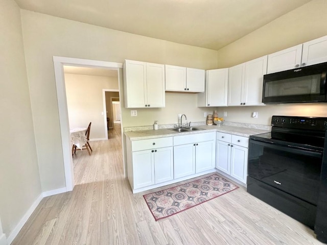 kitchen featuring a sink, black appliances, light countertops, and white cabinetry