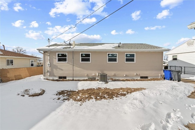 snow covered house with fence and central AC unit