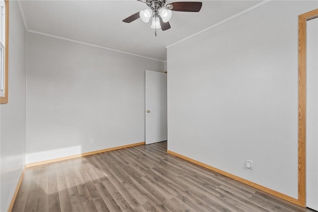 unfurnished room with light wood-type flooring, baseboards, a ceiling fan, and ornamental molding