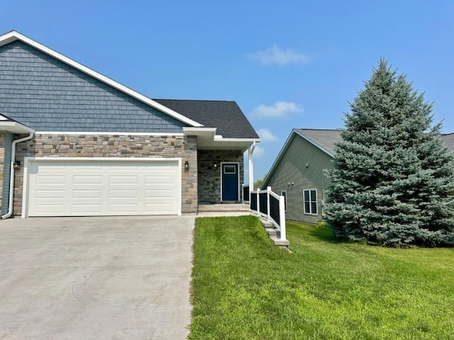 view of front of home with a garage, stone siding, driveway, and a front lawn