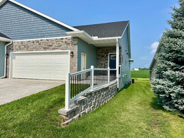 view of property exterior featuring central AC unit, a garage, stone siding, a yard, and driveway