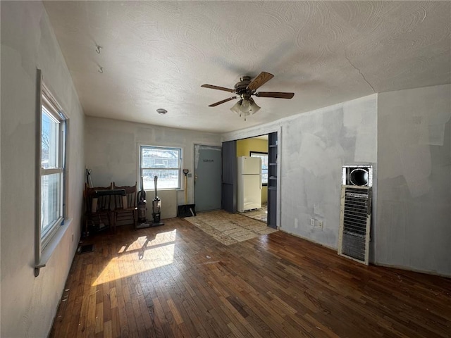 interior space with a textured ceiling, ceiling fan, and wood finished floors