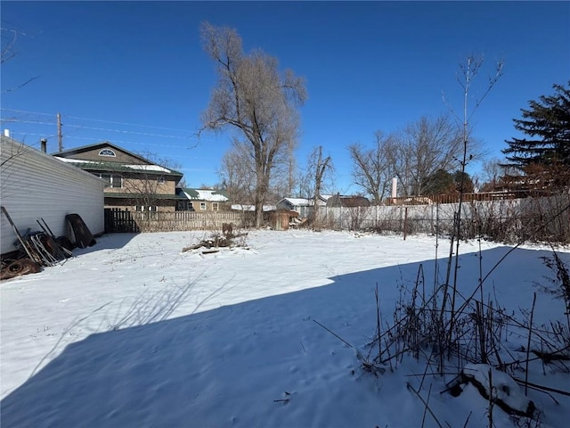 yard covered in snow featuring fence