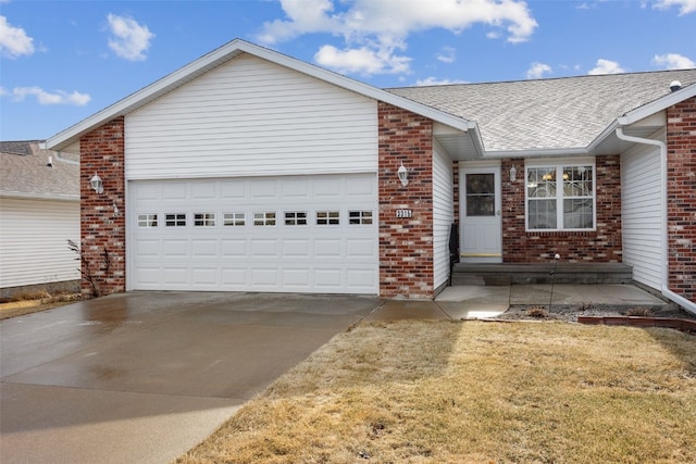 ranch-style home featuring a garage, concrete driveway, roof with shingles, a front lawn, and brick siding