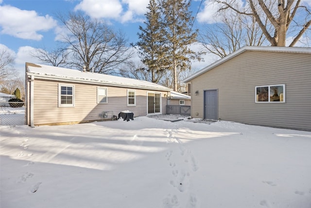 snow covered rear of property featuring fence