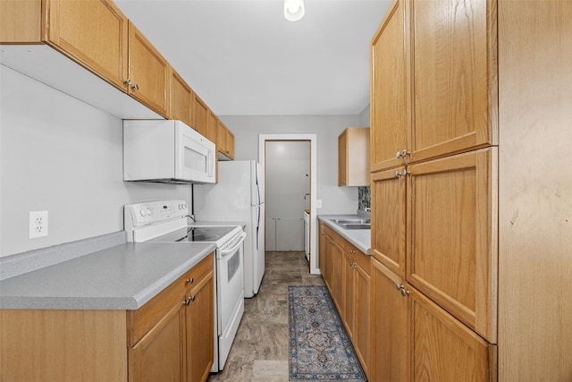 kitchen featuring light countertops, white appliances, and a sink