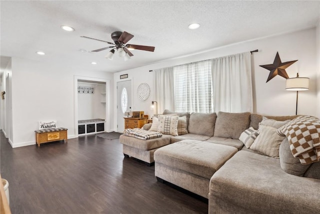 living area featuring a textured ceiling, ceiling fan, recessed lighting, baseboards, and dark wood finished floors