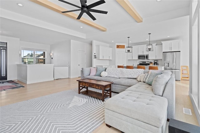 living room featuring visible vents, ceiling fan, beamed ceiling, light wood-type flooring, and recessed lighting