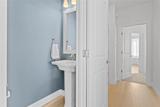 bathroom with wood finished floors and baseboards