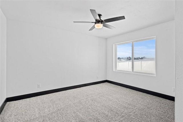 carpeted empty room with a ceiling fan and baseboards