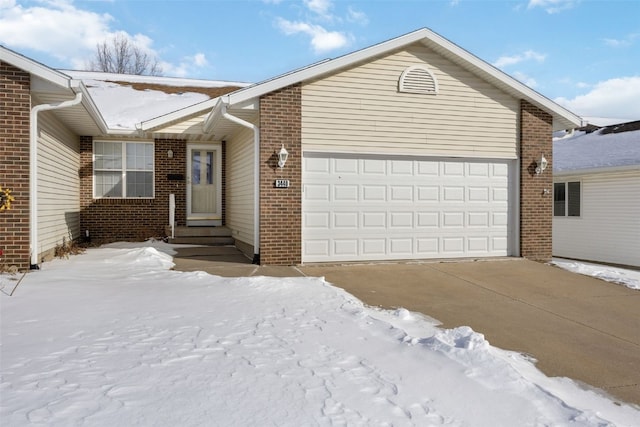 single story home featuring entry steps, driveway, brick siding, and an attached garage