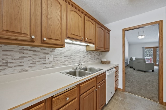 3440 Sunburst Ave, Marion, IA 52302 - kitchen featuring decorative backsplash, light countertops, a textured ceiling, a sink, and dishwasher